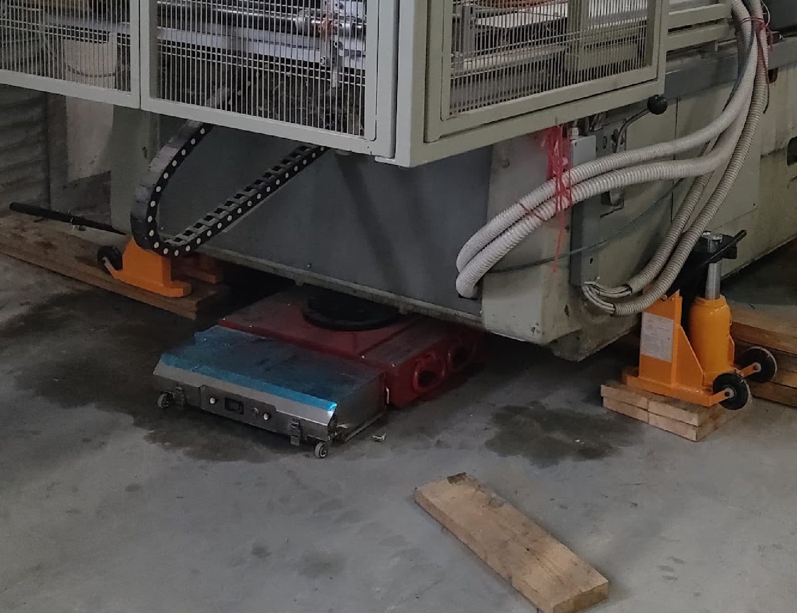 Maszyna podbudowana na kantówkach i uniesiona podnośnikami pazurowymi, z podłożonymi rolkami transportowymi RC